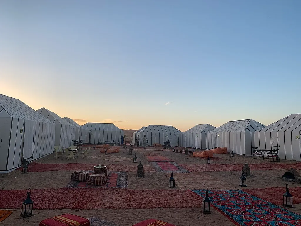 Inside a Merzouga luxury camp tent looking out at the dunes.