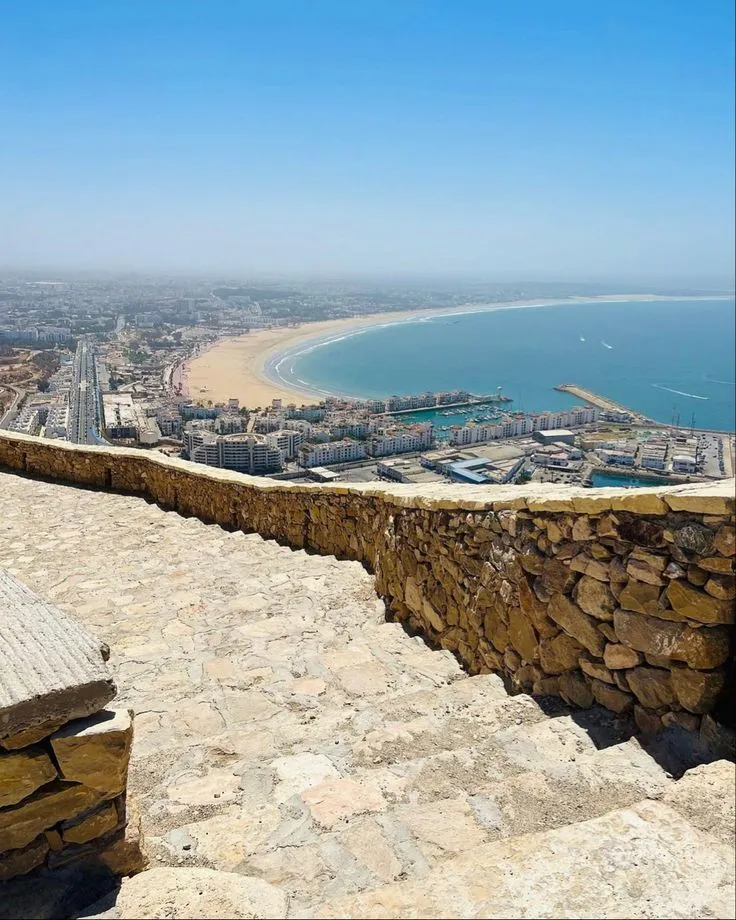 Panoramic view of Agadir city, the sandy bay, and the marina as seen from the historic Agadir Oufella (Kasbah) ruins.